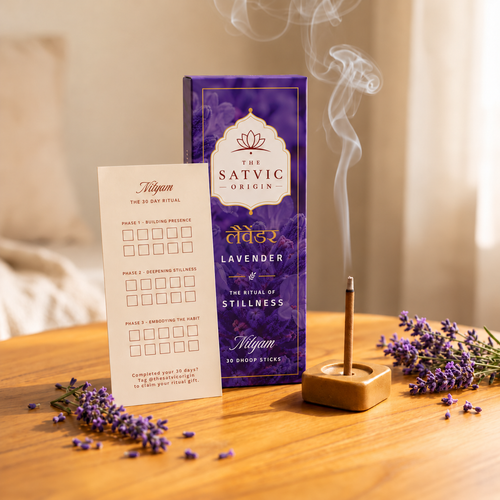 A purple box of The Satvic Origin Lavender incense sticks stands on a wooden table beside a lit incense stick in a wooden holder, with lavender sprigs scattered around and smoke rising.